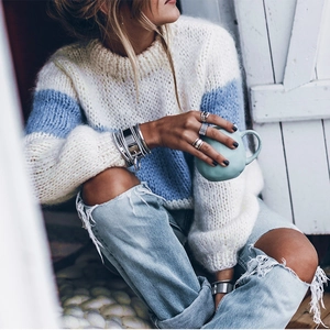 Detail of loose knit mohair striped sweater in cream and blue with casual denim style