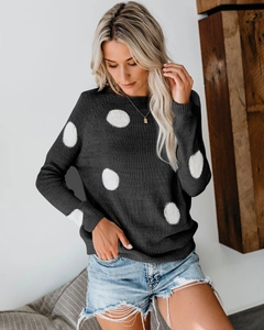 Detail of dark grey knit sweater with white polka dots and ribbed cuffs