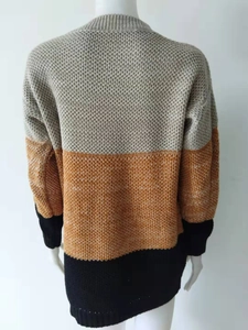Detail of color-block knit sweater texture in gray, mustard orange, and black panels