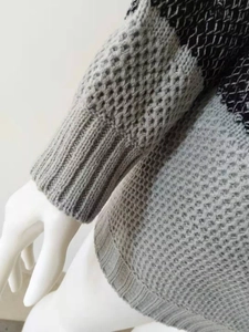 Detailed macro of grey and black striped knit sweater with mesh hollow texture and ribbed cuffs