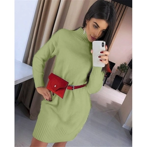 Detail of mock neck knit dress in green featuring wide ribbed cuffs and red waist bag belt