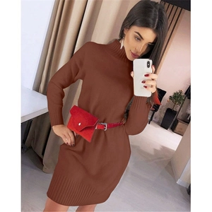 Detail view of a brown knit turtleneck dress with a red waist bag and ribbed cuffs