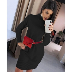Detail of a long-sleeved turtleneck knit dress in black with a red buckled waist bag accent