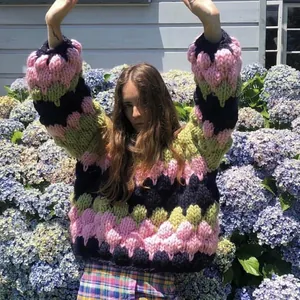 Detail of chunky knit sweater featuring colorful popcorn texture and oversized wool sleeves