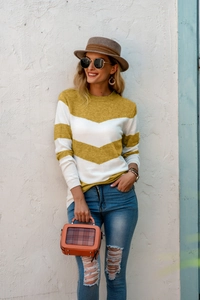 Outdoor shot of a mustard and white chevron striped knit sweater for women