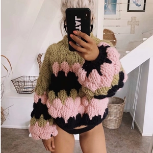 Detailed macro view of the thick chunky knit texture and colorful wool blocks on the sweater