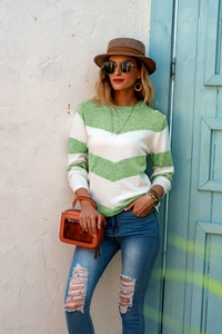 Detail of green and white wavy stripe knit long sleeve top with soft fabric texture