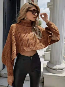 Detail of chunky knit turtleneck sweater with stylish oversized cape-style batwing sleeves