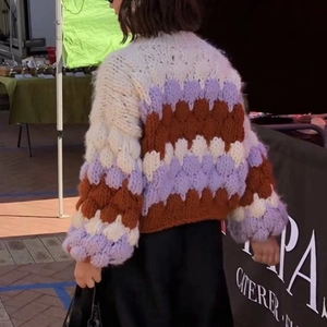 Detail showing back view of oversized chunky knit cardigan with puff sleeves and color blocks