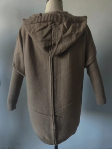 Macro detail of the back seam and thick knit texture on a hooded long cardigan
