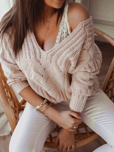Close-up of pink cable knit sweater with deep V-neck and delicate white lace camisole