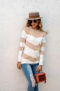 Detail of a slim-fit knit sweater with beige and white chevron stripes and ribbed cuffs