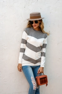 Street style shot of a slim-fit striped knit sweater with grey and white V-patterns