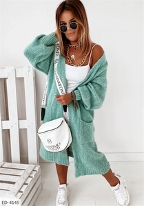 Detail view of mint green chunky knit cardigan with large functional pockets and textured fabric