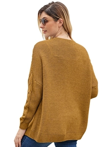 Detailed macro view of ginger yellow chunky cable knit cardigan with crochet sleeve details