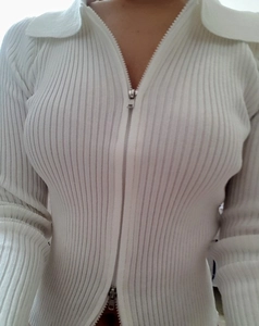 Detail of white ribbed knit cardigan featuring double-headed metal zipper and polo collar