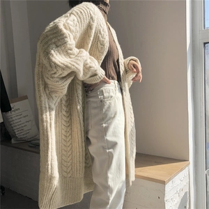 Detailed texture of chunky cable knit cardigan in cream white, oversized fall style