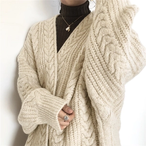 Close-up of heavy-knit chunky cable cardigan in cream white with ribbed cuffs