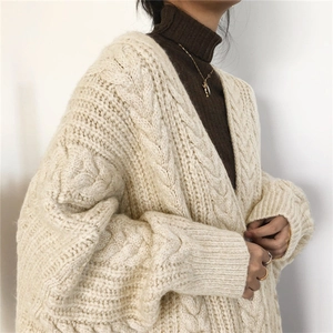 Detailed close-up of chunky cable knit texture on oversized cream cardigan