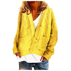 Detail of yellow cable knit cardigan showing diamond texture and large front pockets