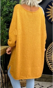 Detail of yellow knit oversized sweater featuring side slits and dropped shoulder seams