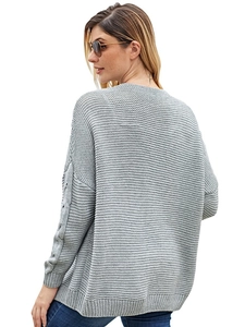 Detail of grey cable knit cardigan featuring unique hollow-out sleeve design and texture