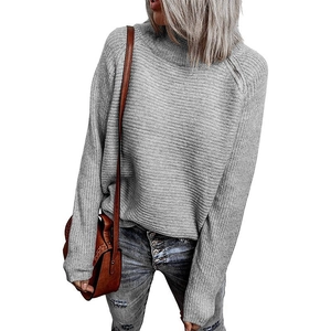Close-up of grey knit sweater showing horizontal texture and metal shoulder zipper detail