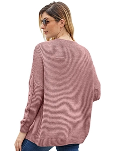 Detail of chunky cable knit texture and batwing sleeves on a dusty pink cardigan