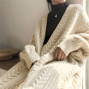 Detail of chunky cable knit texture on oversized cream cardigan for a cozy winter look