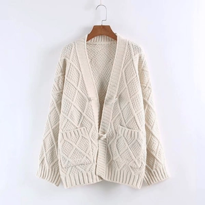 Close-up of cream chunky knit cardigan featuring textured diamond pattern and large pockets