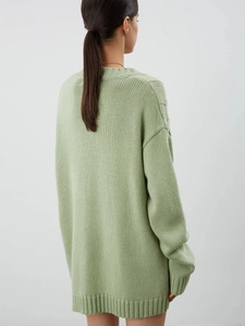 Rear view of long sleeve oversized knit cardigan in light green with heart buttons