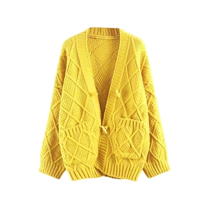 Macro shot of yellow diamond knit pattern on buttoned V-neck short sleeve cardigan