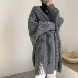 Detail of grey oversized cable-knit cardigan showing heavy knit texture and relaxed fit