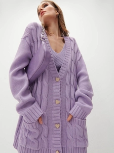 Macro detail of purple cable-knit cardigan featuring decorative heart-shaped buttons