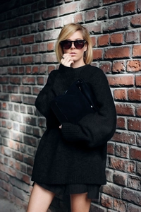 Vue détaillée du pull en maille noir oversize avec col rond et texture douce effet polaire