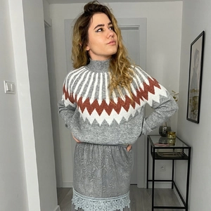 Detail of grey Nordic knit sweater with geometric patterns and lace-trimmed skirt set