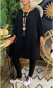 Detail of the chunky black knit texture and crew neckline on a loose oversized sweater