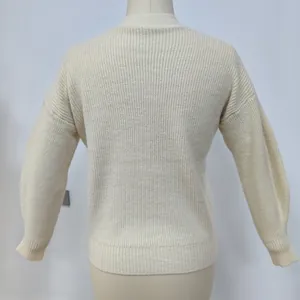 Detail view of cream knit cardigan featuring vertical ribbed texture and ribbed cuffs
