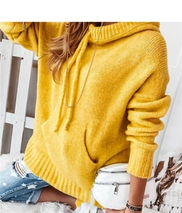 Detail of yellow knit hoodie featuring a drawstring hood and large kangaroo pocket