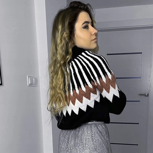 Detail view of ethnic knit sweater with geometric diamond patterns and high collar texture