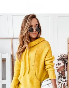 Detail of ginger knit hoodie featuring texture, gold glasses chain, and white embossed bag