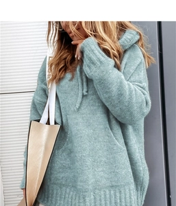 Detail of light blue oversized knit hoodie with kangaroo pocket and drop shoulder style