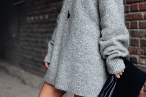 Gros plan sur la texture du pull en maille mohair grise avec poignets côtelés élégants