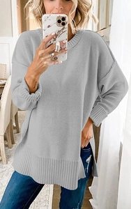 Detail eines hellgrauen Strickpullovers mit Rundhalsausschnitt und Seitenschlitz