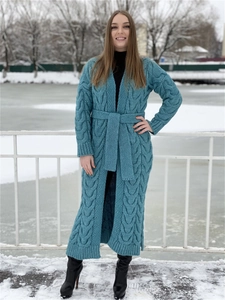 Detail of long knit cardigan with thick cable patterns and matching waist belt in dark teal