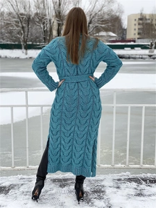 Detail of teal chunky knit long cardigan with cable pattern, belt and high side slit