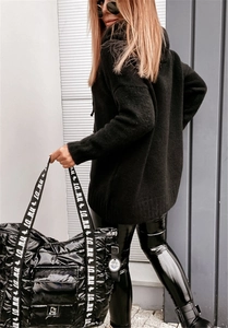 Street style detail of a black oversized knitted hoodie and quilted tote bag with branding