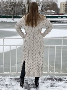Detail of chunky knit texture and cable pattern on beige long cardigan in snow