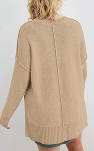 Detail eines übergroßen camelfarbenen Pullovers mit Rippsaum und vertikaler Rückennaht