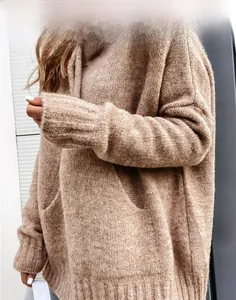 Detailed macro view of the camel oversized knitted sweater featuring a large kangaroo pocket